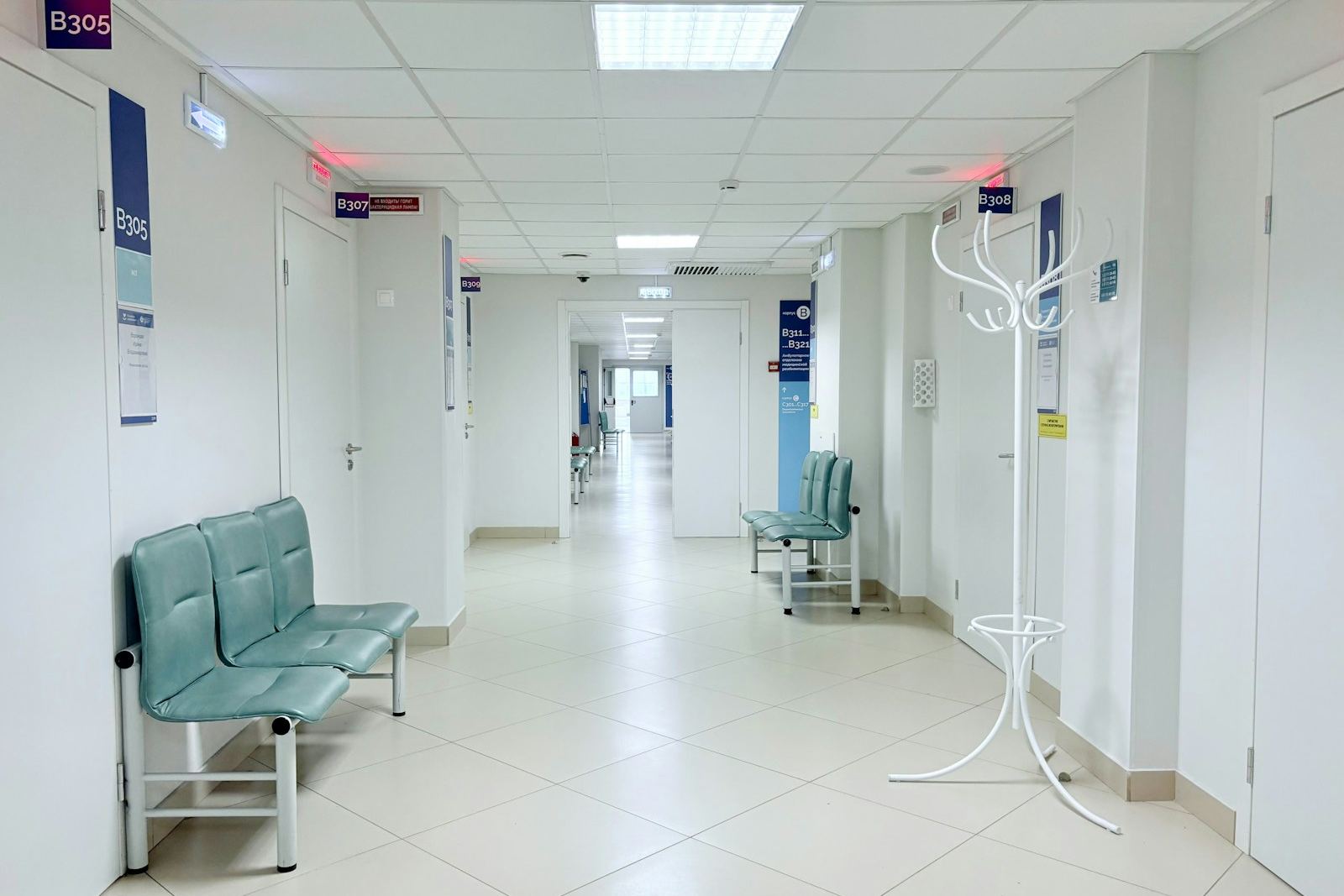 Leerer Krankenhausflur mit Türen zu Behandlungsräumen – typischer Bereich, in dem die Raumdruckregelung Druckstufen zwischen Fluren, OP und Isolierzimmern hält