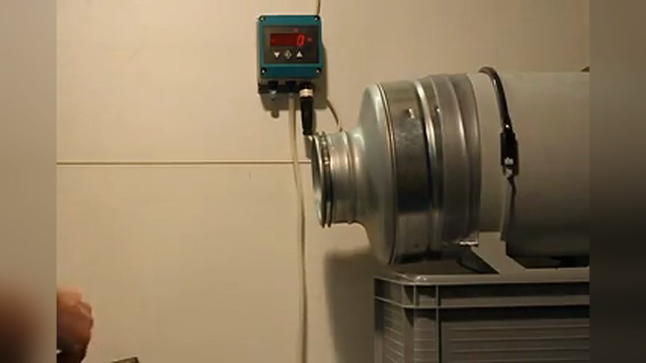 Standbild aus dem Video „Druckstoß“: HaNu 2009 im Prüfaufbau neben einem Differenzdruck-Anzeigegerät